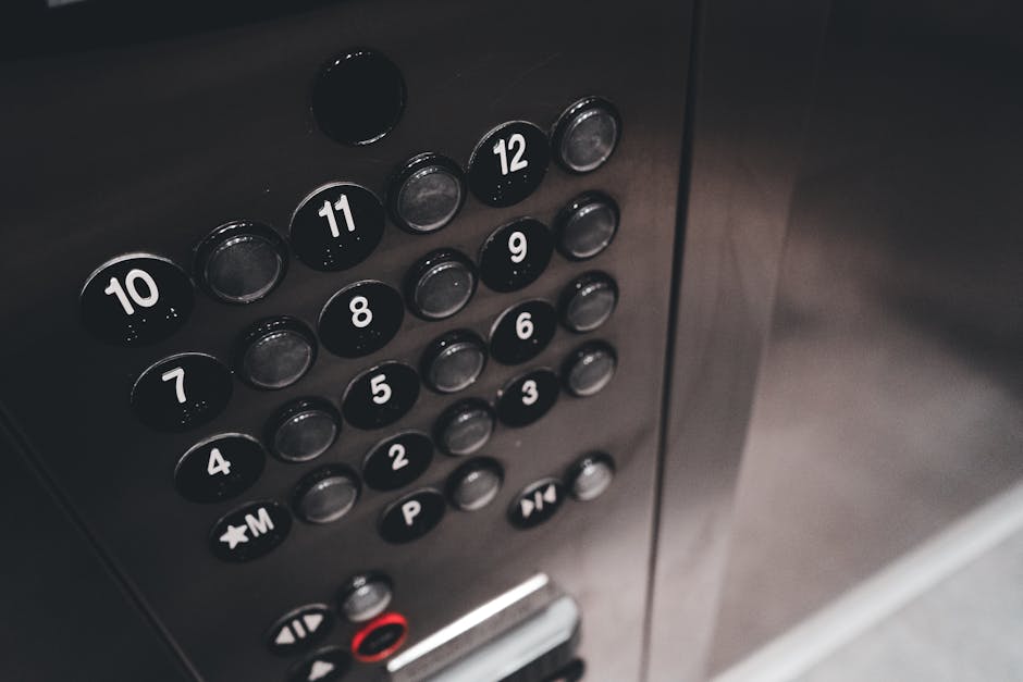Detail view of a sleek elevator control panel with metallic finish and numbered buttons.